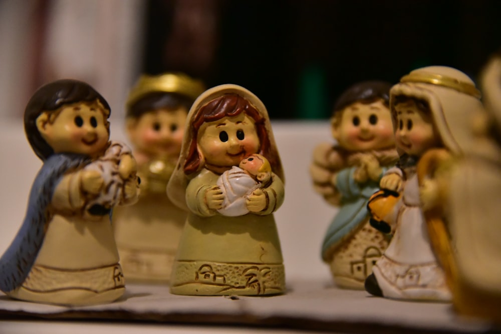 a group of little figurines of people holding a baby