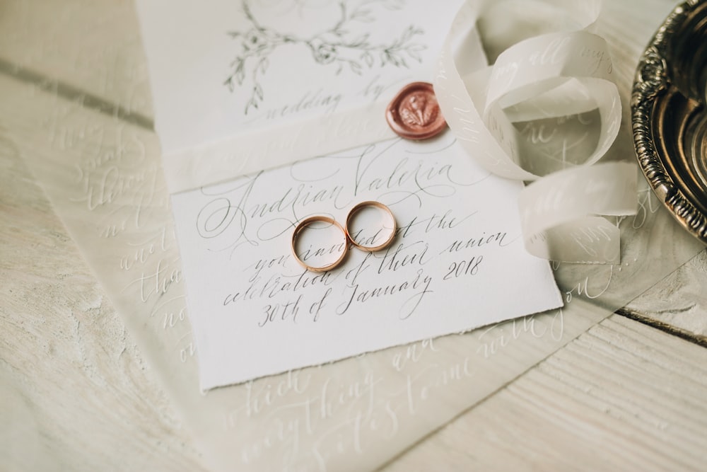 two wedding rings laying on top of a piece of paper