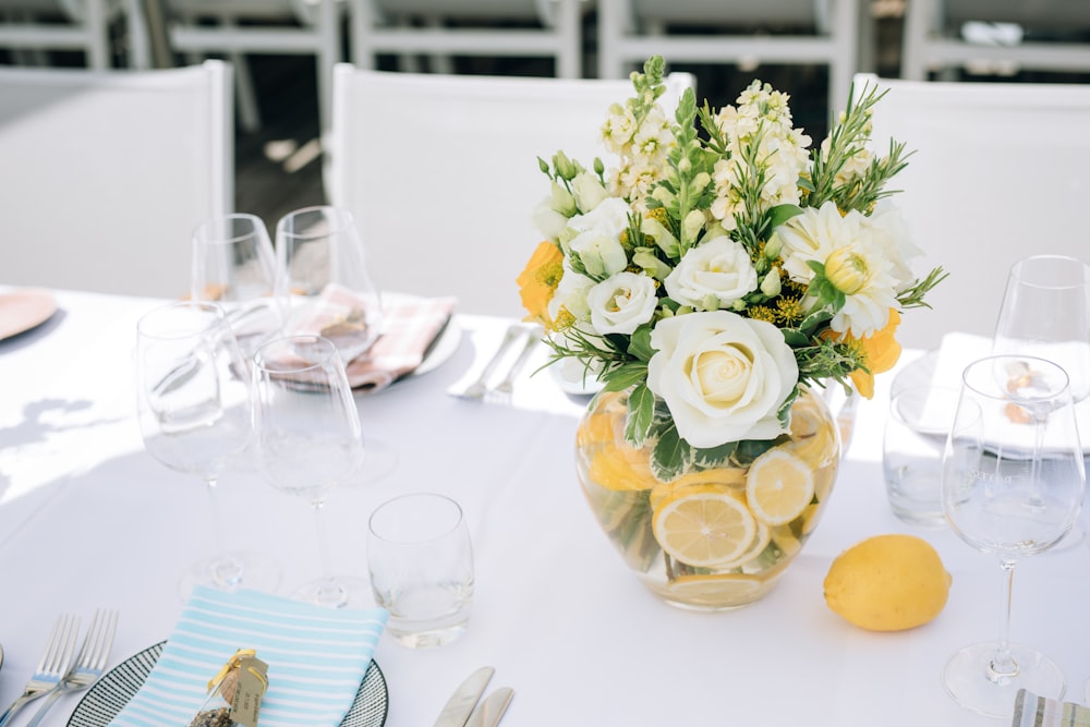 a vase filled with white and yellow flowers on top of a table