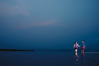 A serene couple holding hands under a starlit sky.