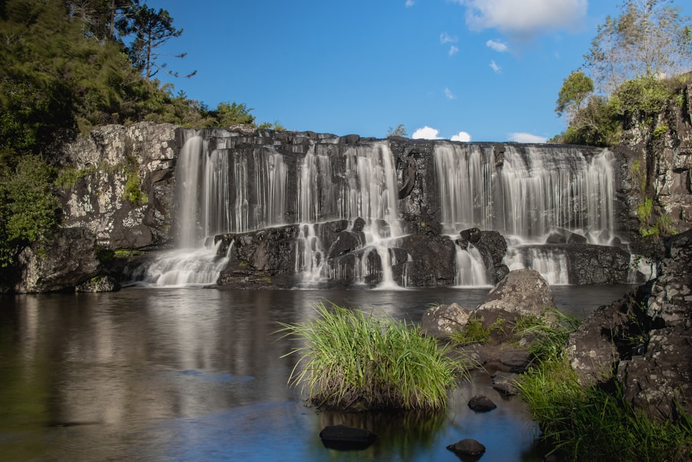 a waterfall with a body of water in front of it