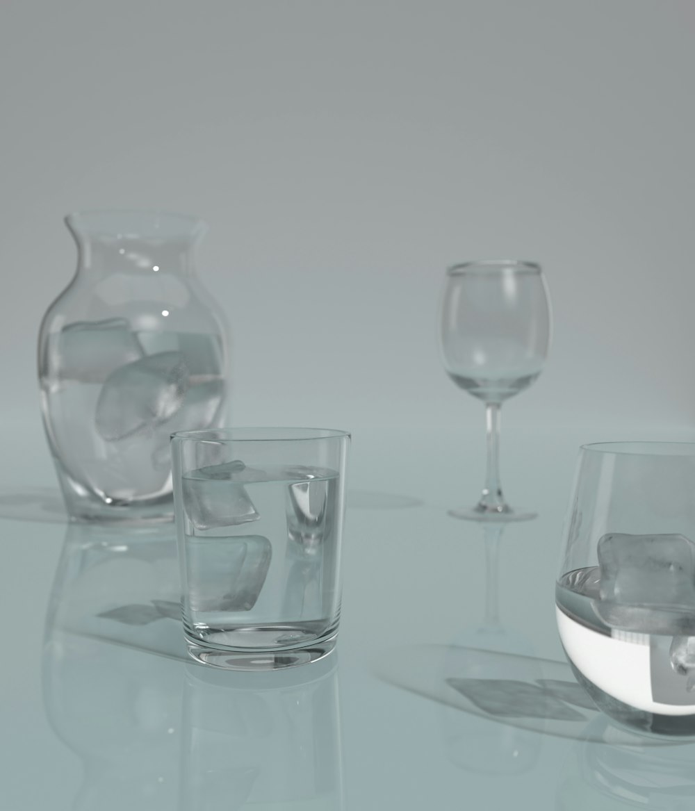 a table topped with glasses and vases filled with water