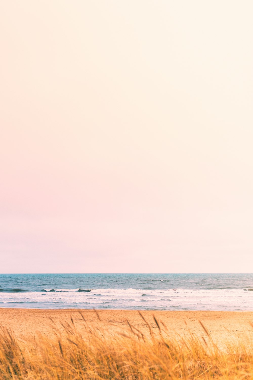 a person standing on a beach holding a surfboard