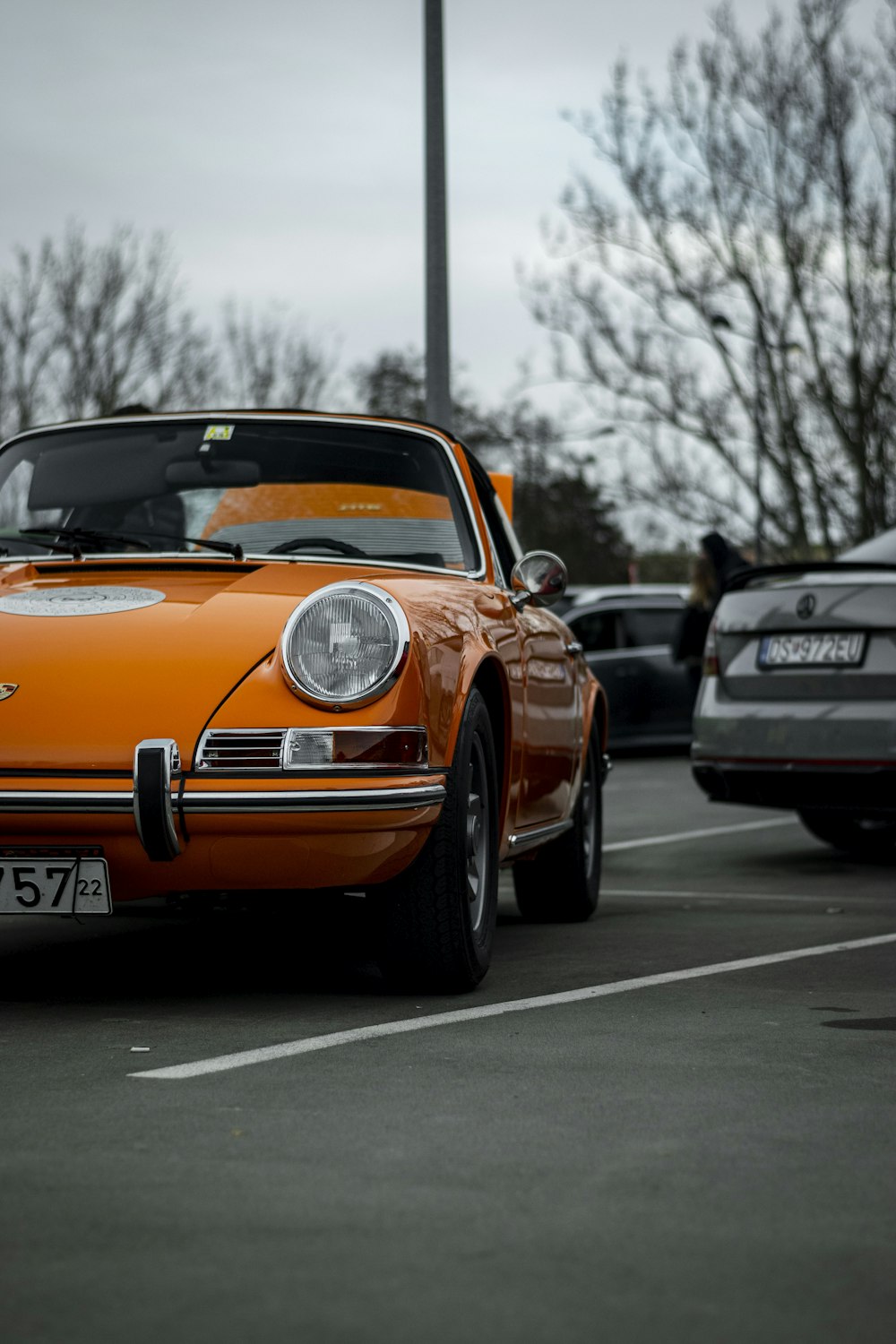 an orange sports car parked in a parking lot