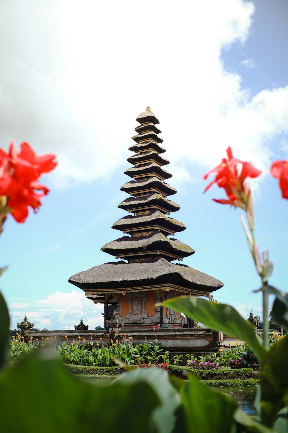 a tall tower with a bunch of flowers in front of it