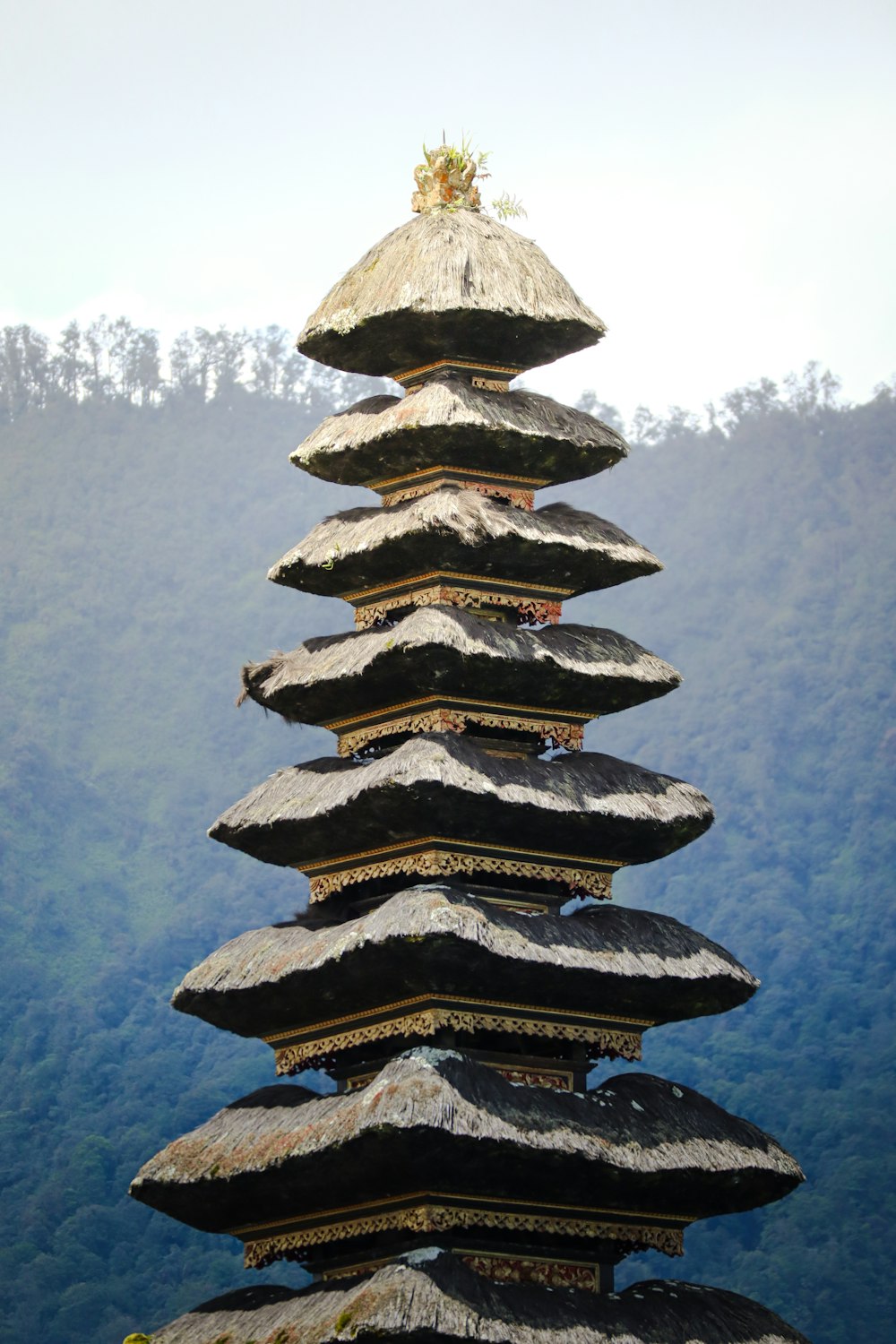 a tall stack of rocks sitting on top of a lush green hillside