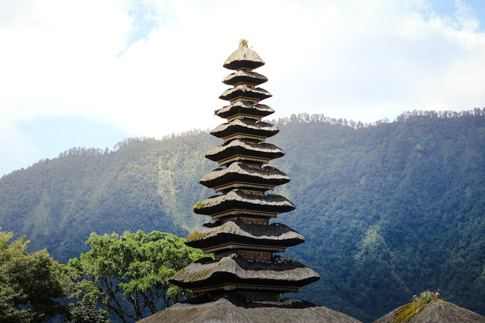a tall tower made of rocks sitting on top of a lush green hillside