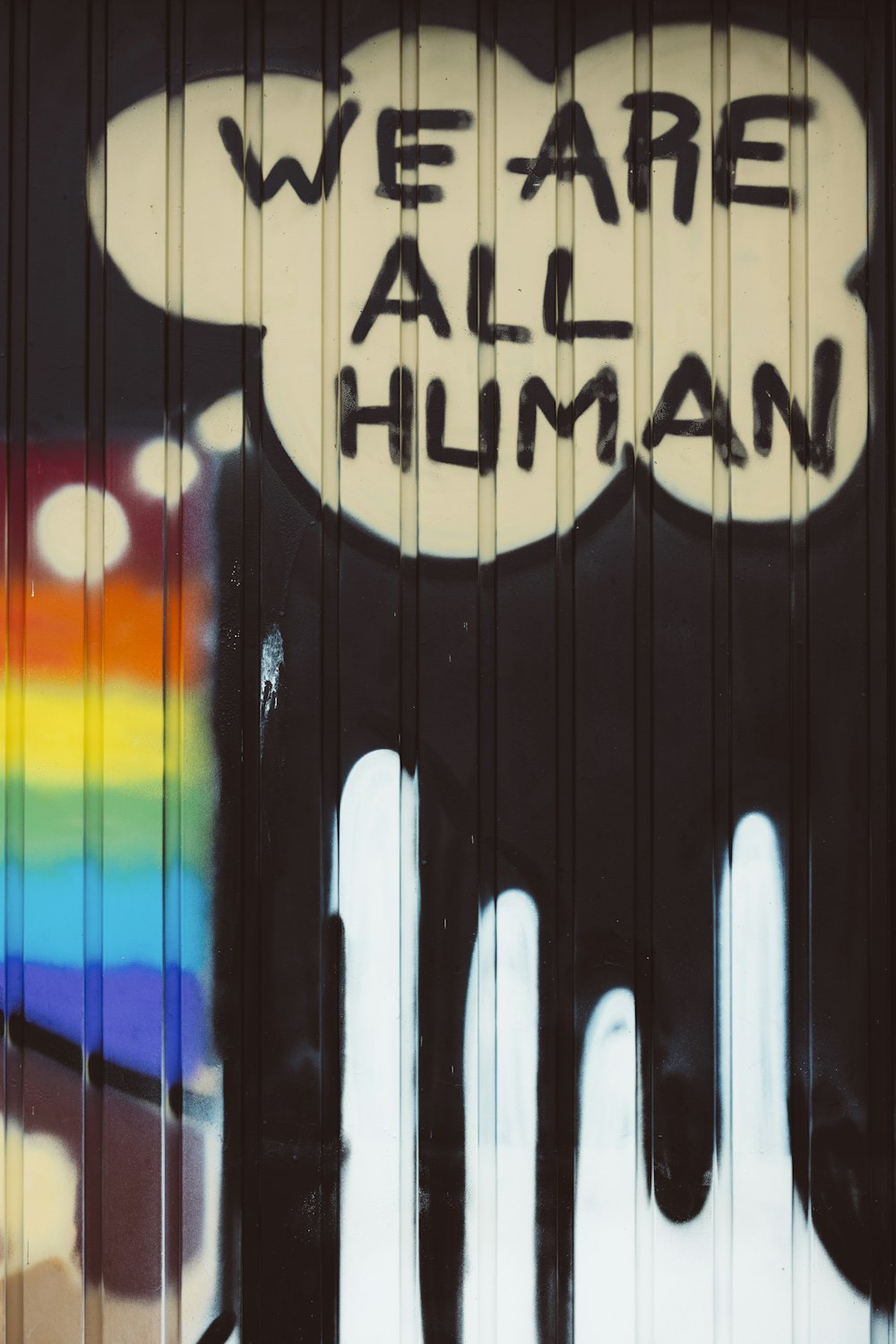 we are all human written on the side of a building