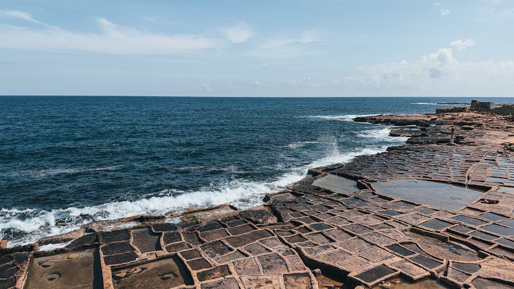 a large body of water sitting next to a rocky shore