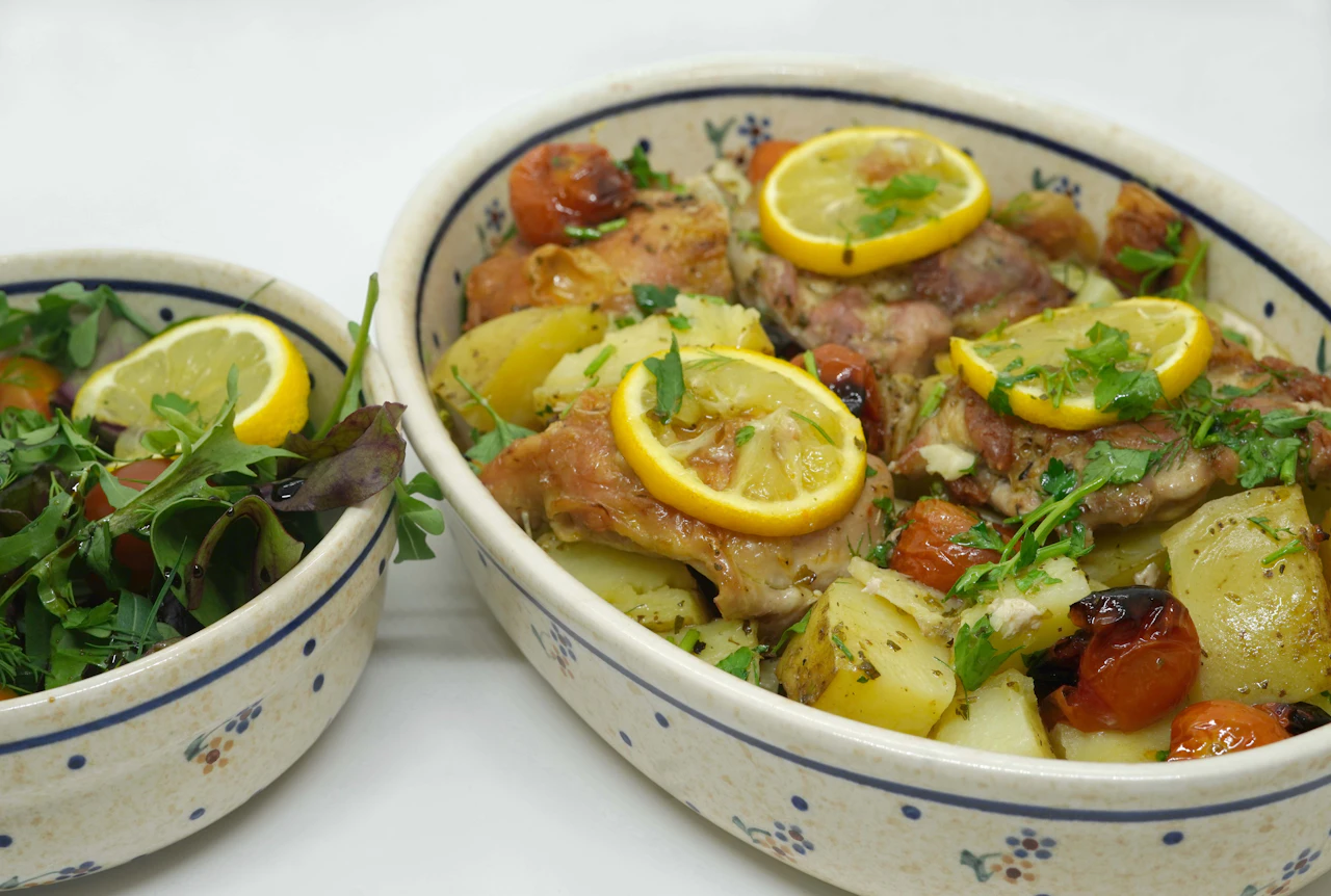 Moroccan chicken tagine with fresh lemon, braised meat and vegetables in ceramic bowls