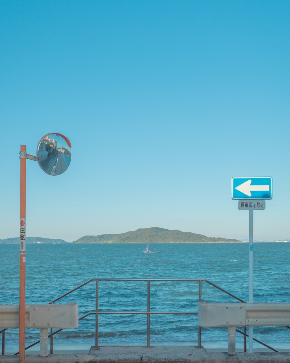 a street sign on the side of a road next to a body of water