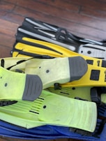 Close-up of sleek swim fins and paddles neatly arranged on a poolside bench.