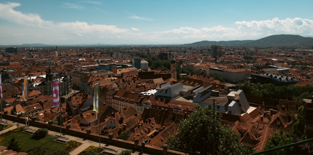 an aerial view of a city with buildings and mountains in the background