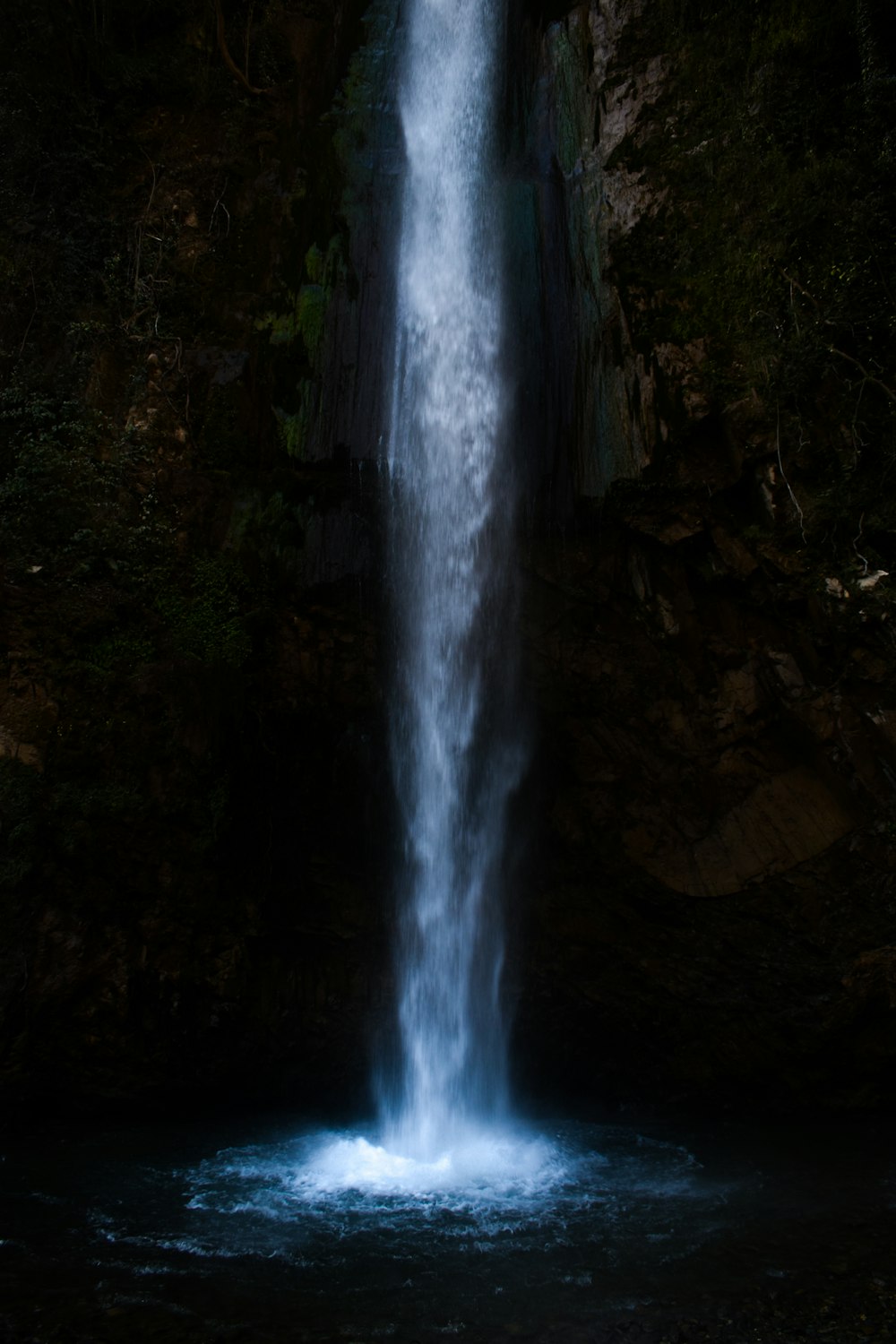 a large waterfall in the middle of a forest