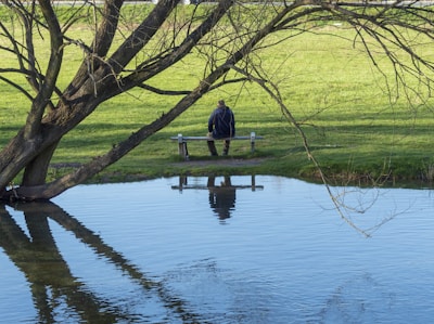 A calm person sitting peacefully outdoors, reflecting and letting go of stress.