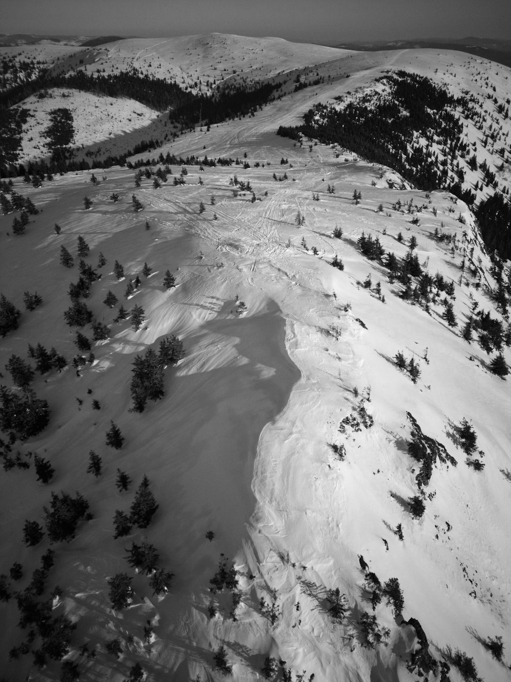 a black and white photo of a snowy mountain