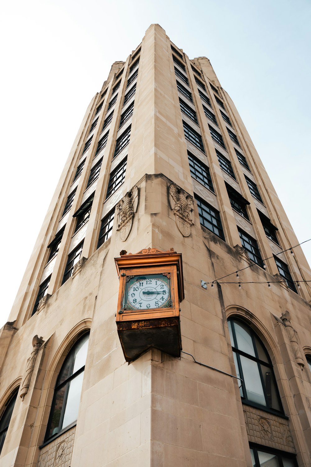 um relógio montado ao lado de um prédio alto