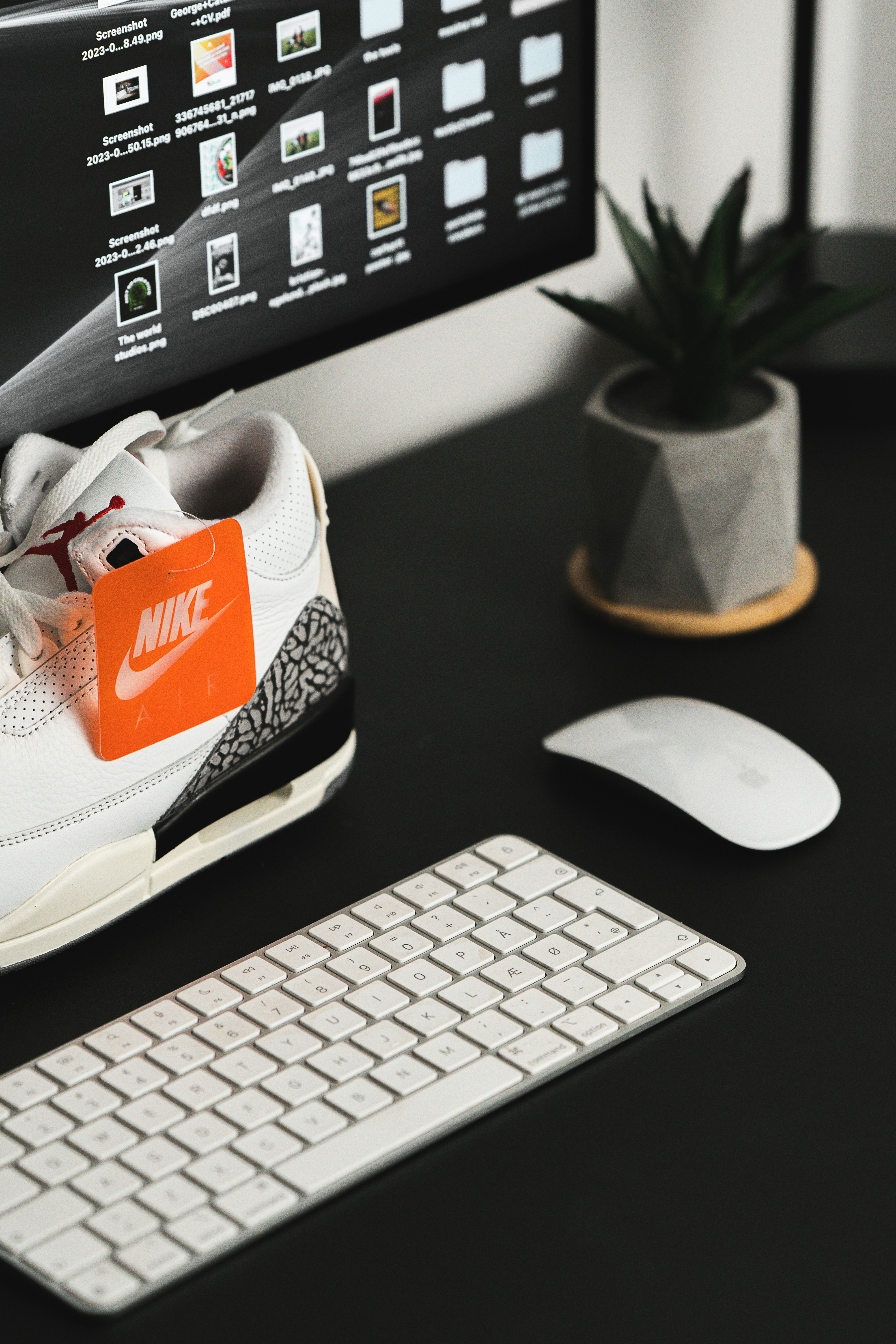 Des baskets avec l’écart Nike sur un bureau avec un ordinateur.