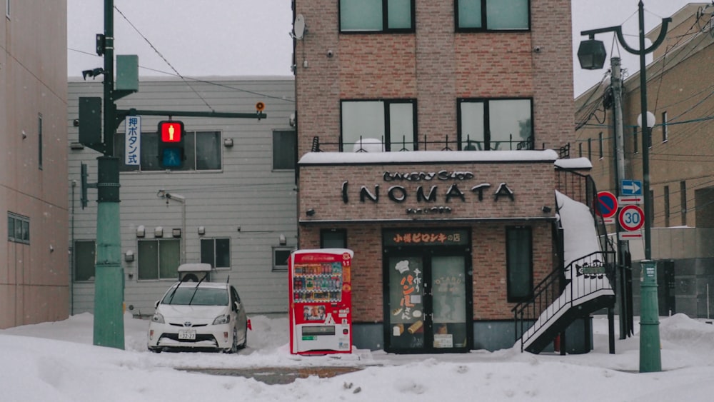 a car is parked in front of a restaurant in the snow