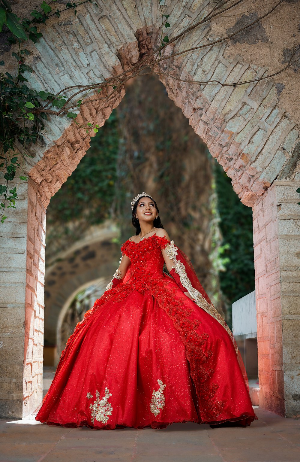 a woman in a red dress standing in an archway