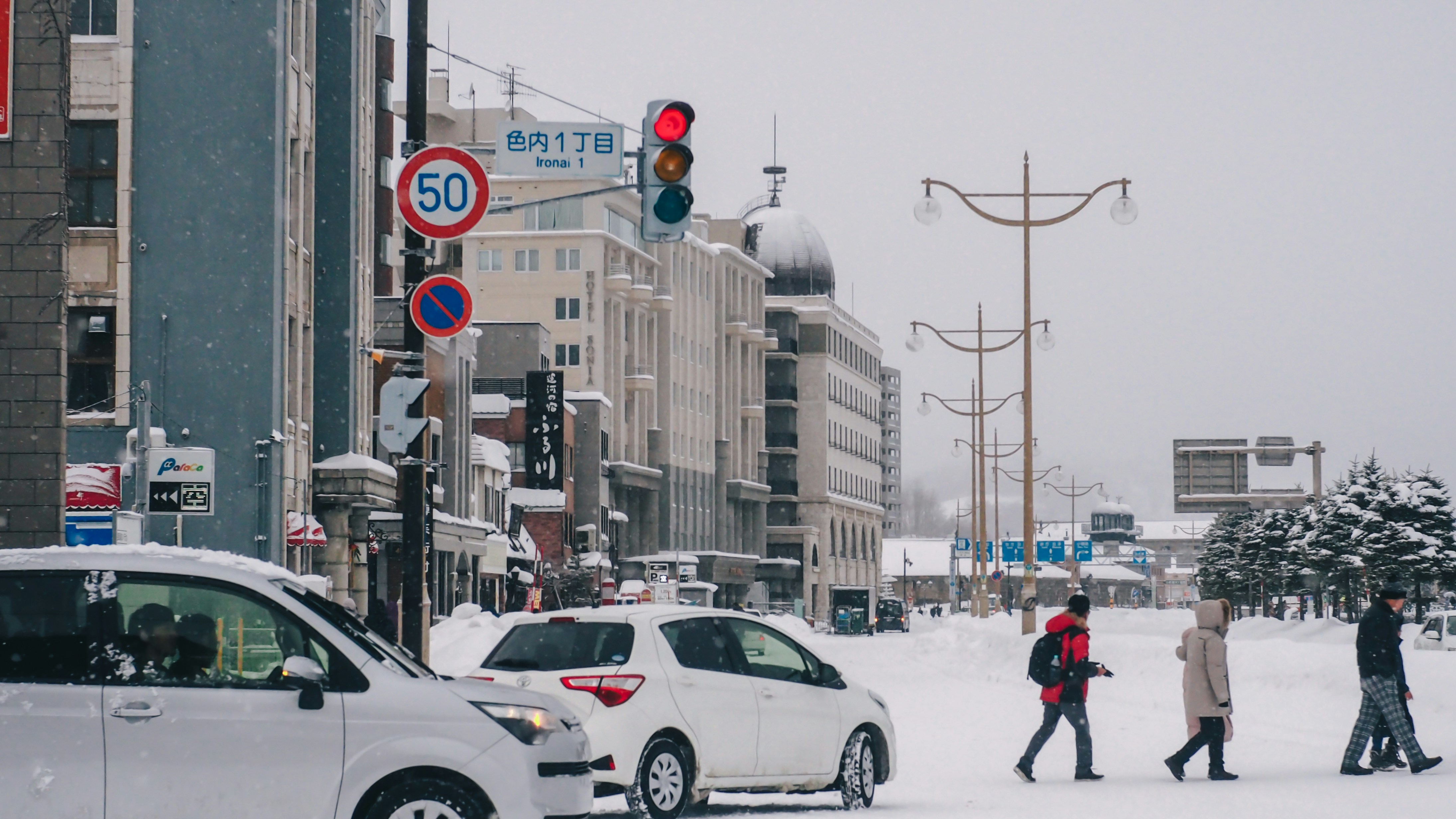 a group of people walking across a snow covered street
