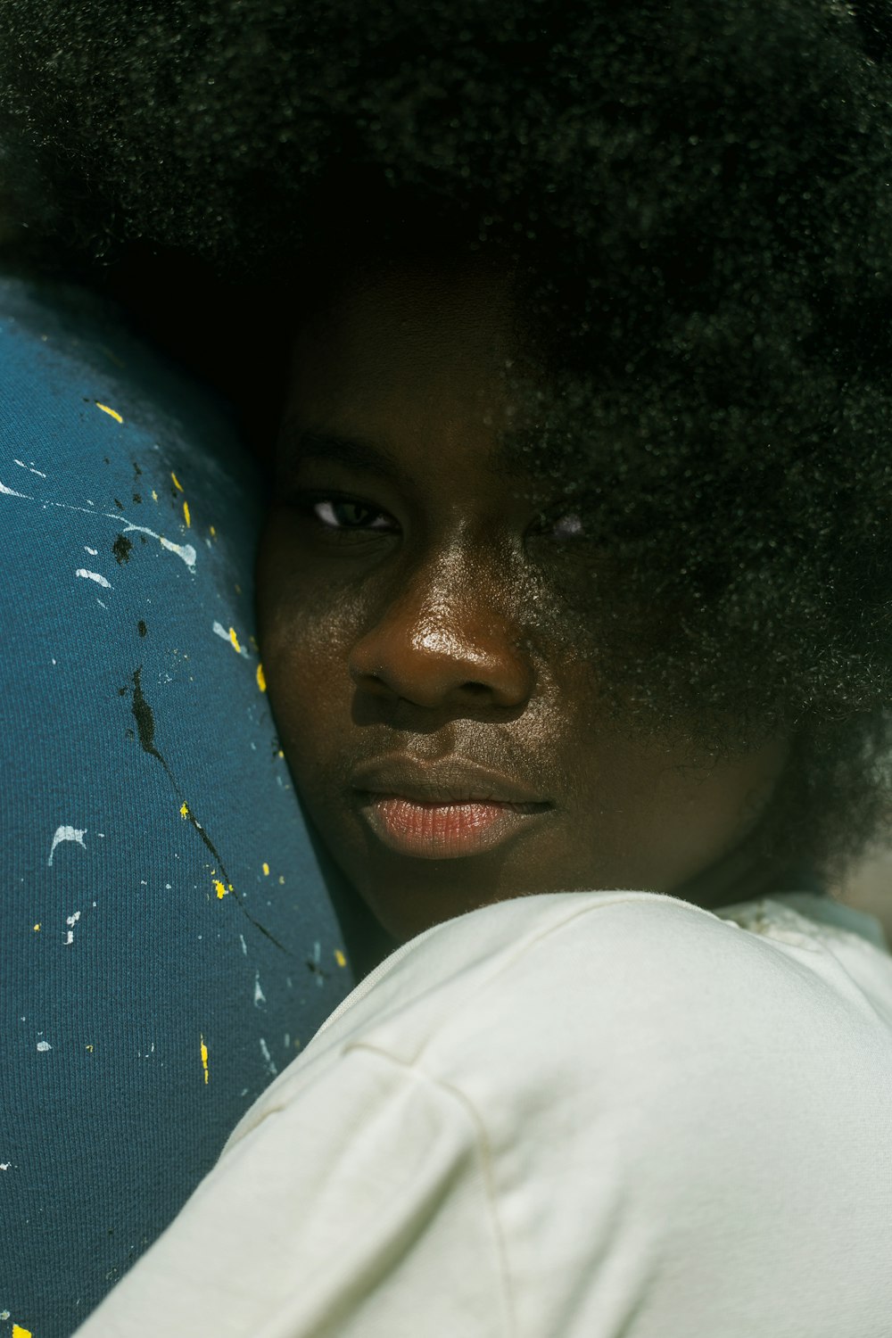 a woman with an afro is holding a surfboard