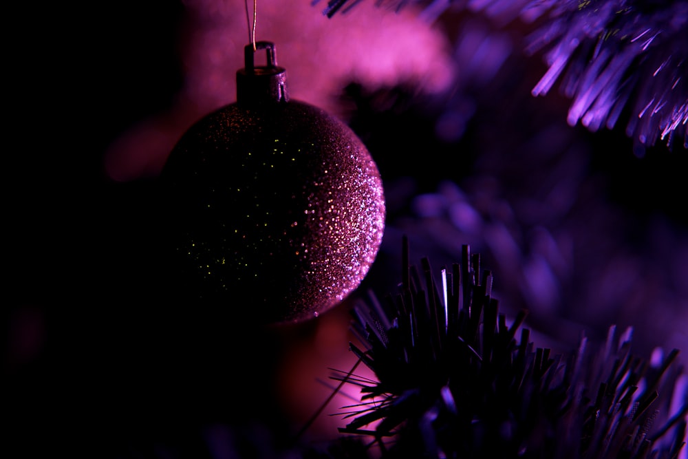 a purple ornament hanging from a christmas tree