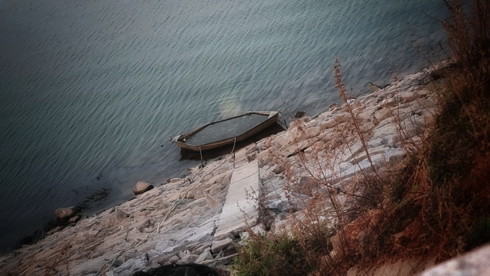 a boat sitting on the shore of a lake