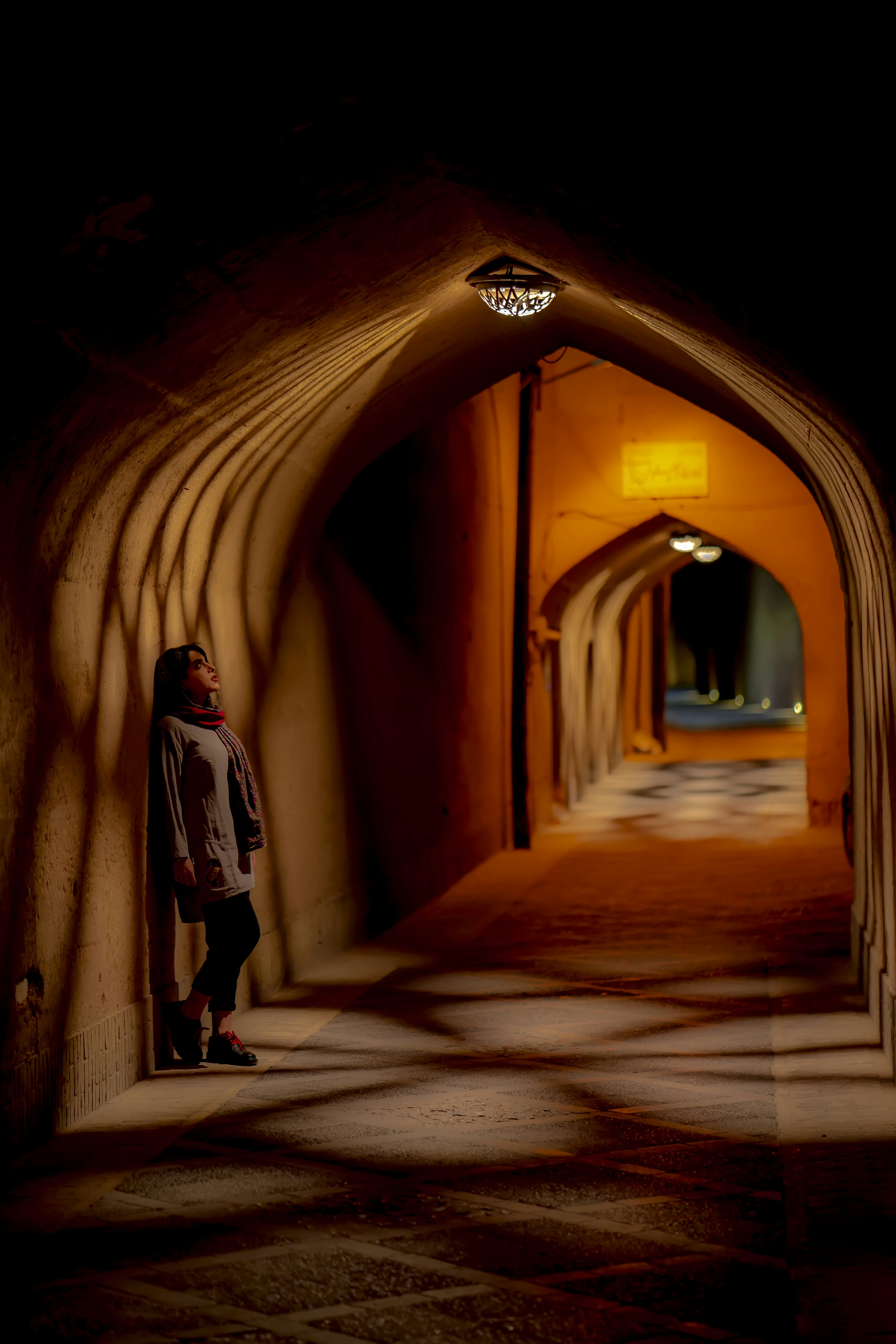 a person standing in a tunnel with their back to the camera