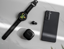 a smart watch and ear buds on a table