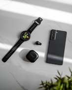 a smart watch and ear buds on a table