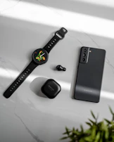 Flat lay of lifestyle elements: fresh fruits, running shoes, and a sleep tracker on a bedside table.