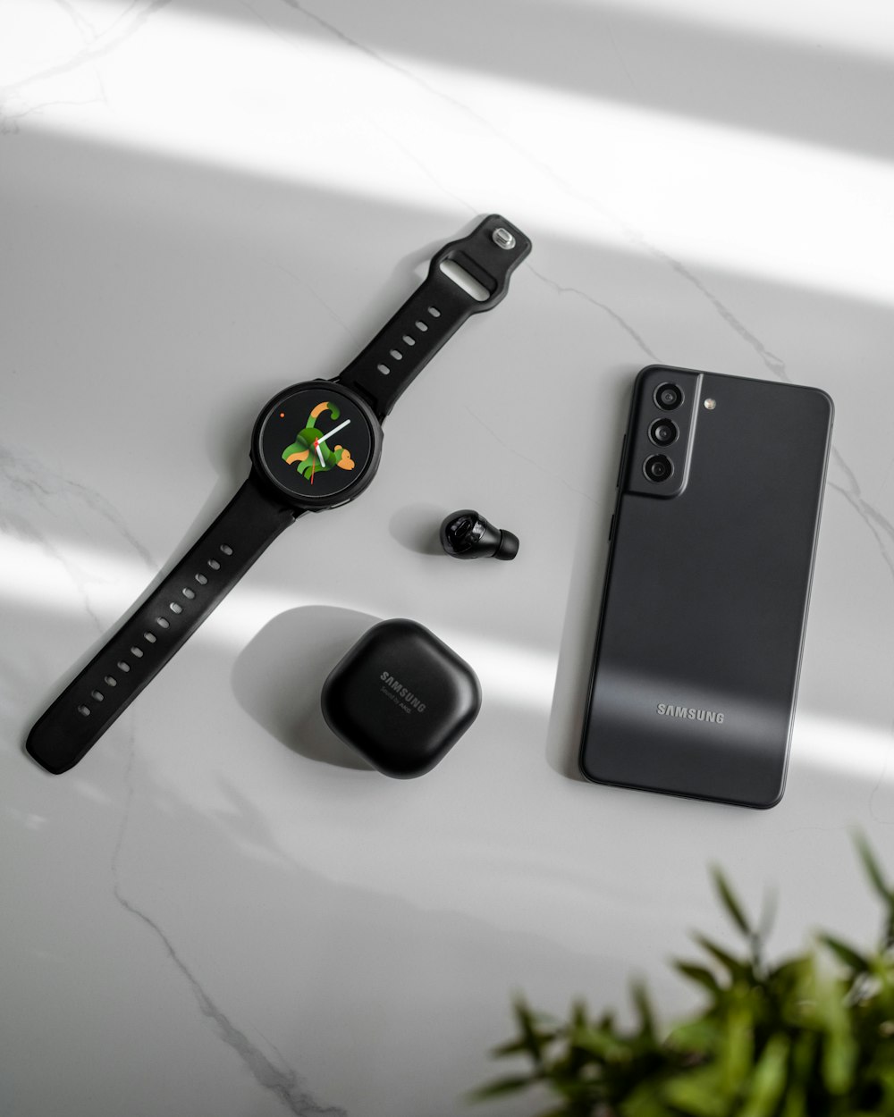 a smart watch and ear buds on a table