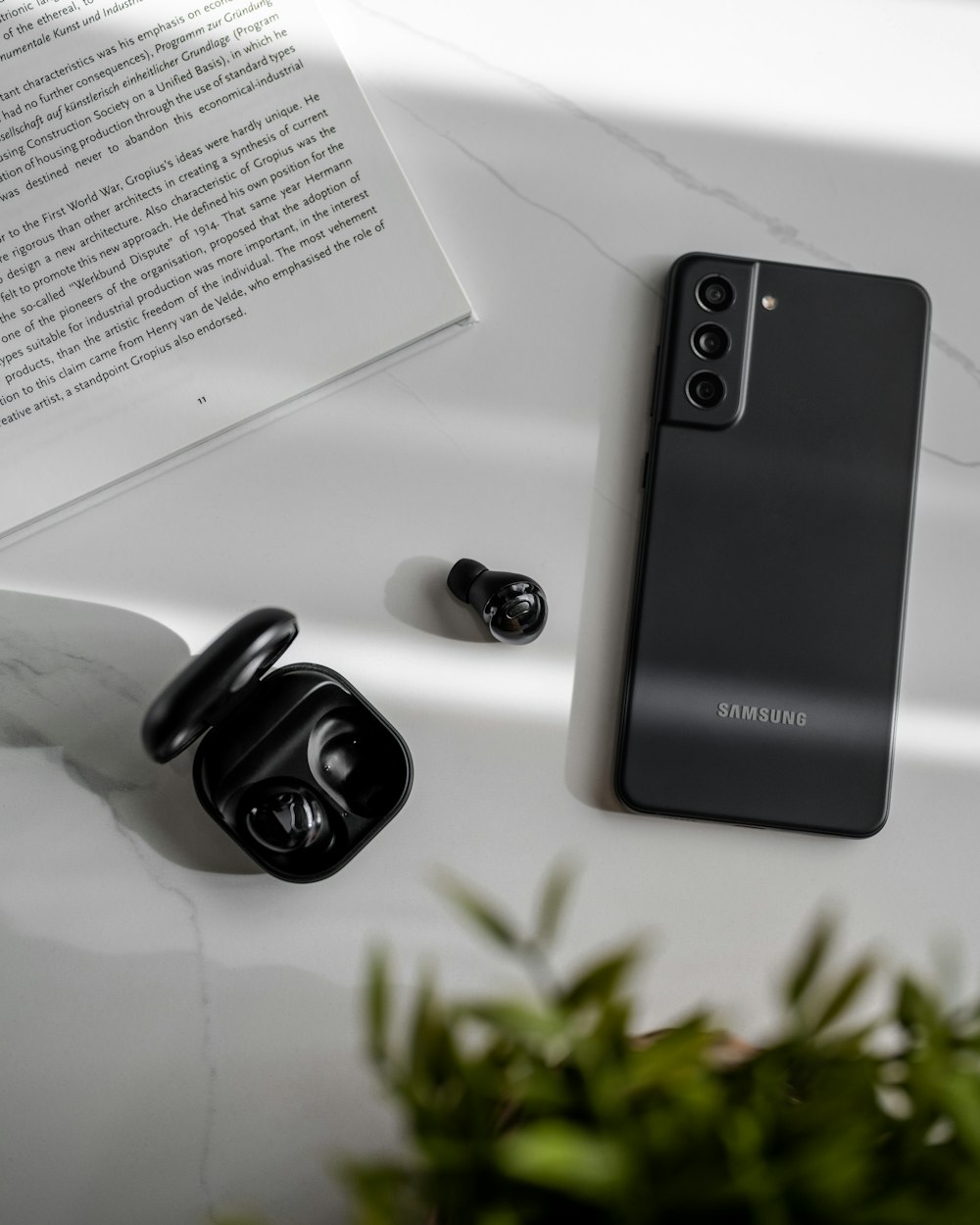 a black samsung phone sitting on top of a white table