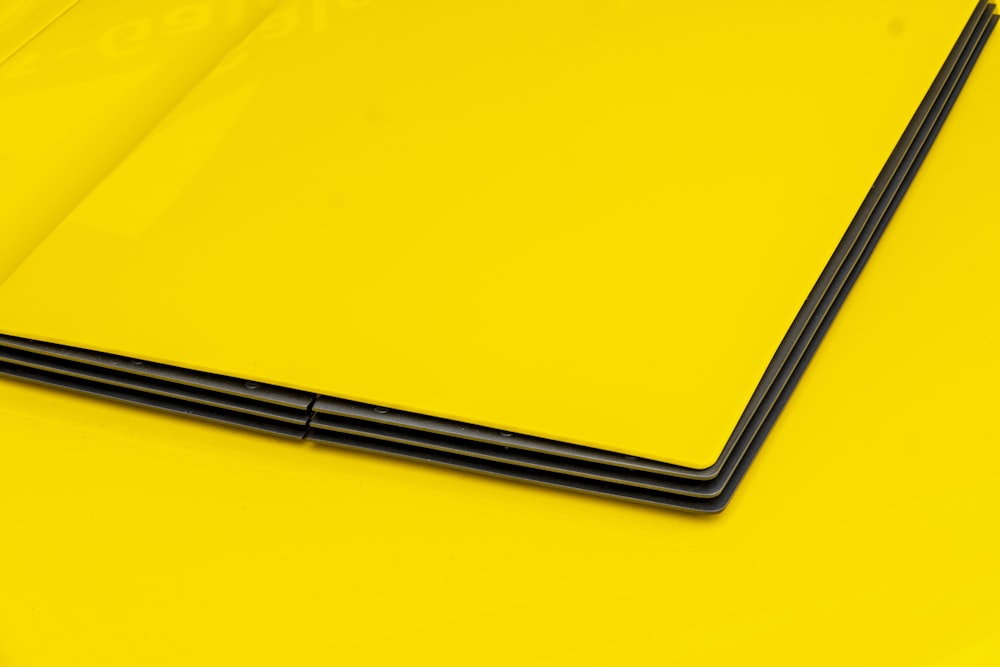 a close up of a laptop on a yellow surface