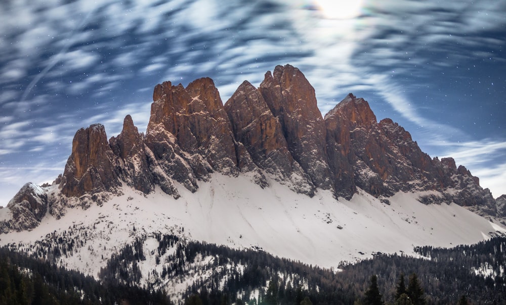 a snow covered mountain under a cloudy sky