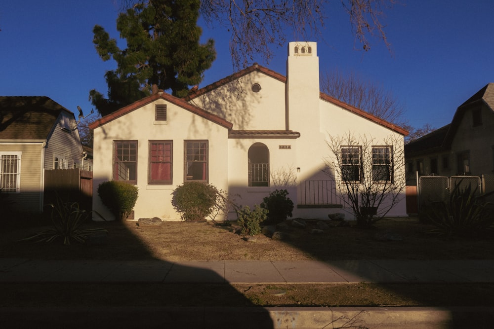 a white house with a red door and red shutters