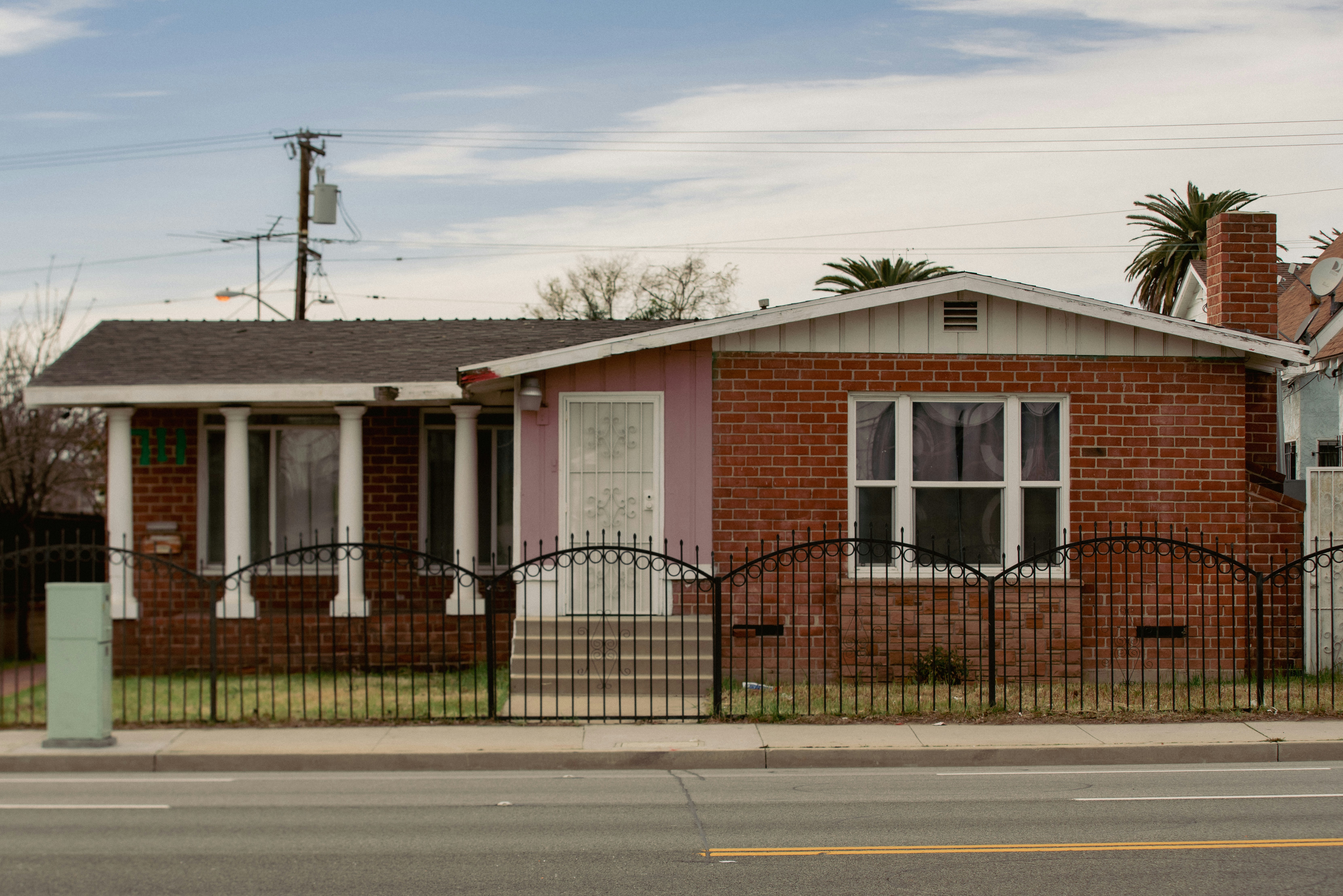 a red brick house with a black iron fence