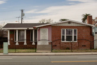 a red brick house with a black iron fence