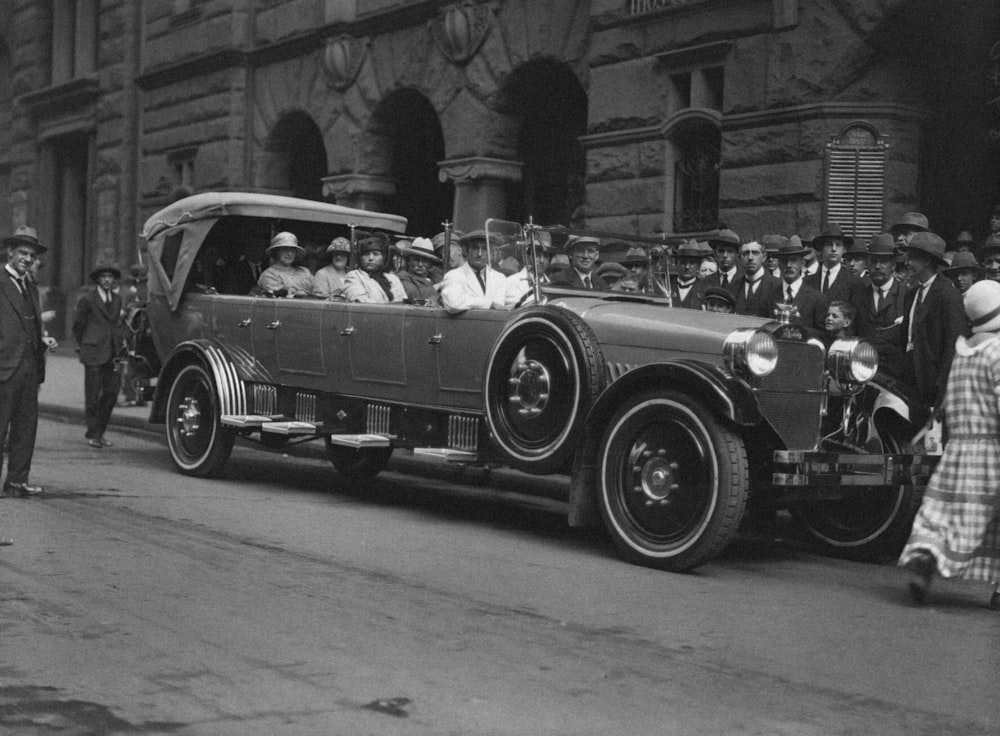 a vintage photo of a car being driven by a group of people