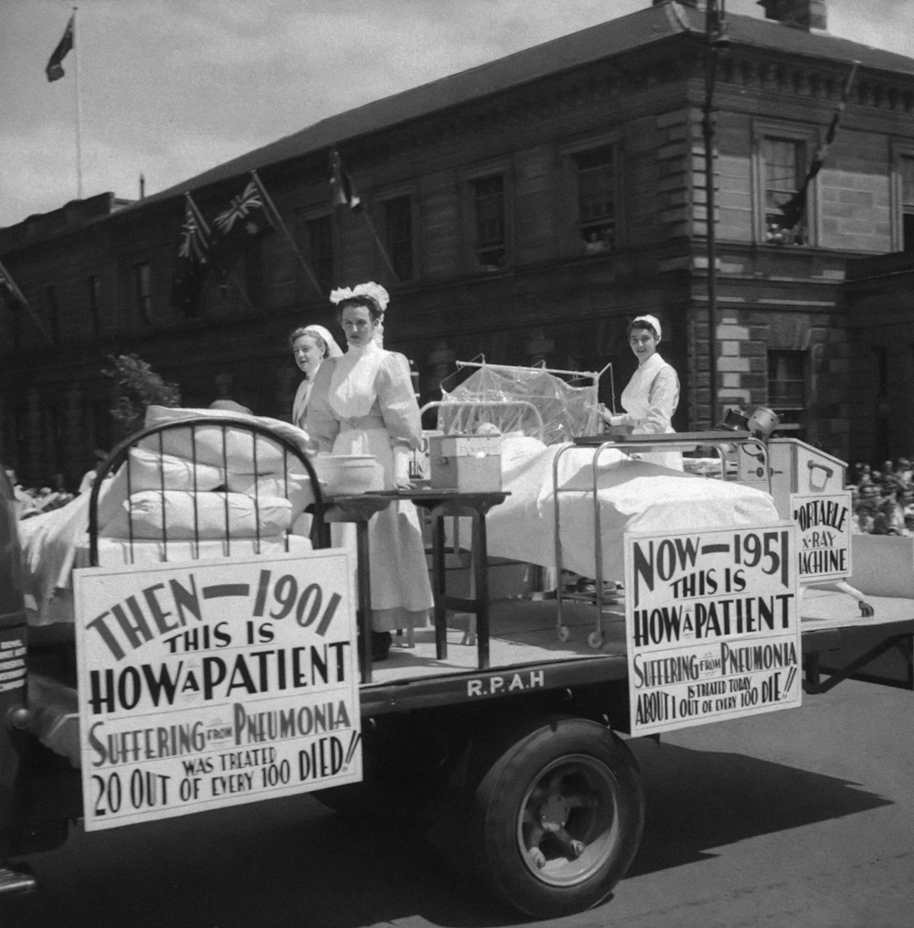 a black and white photo of two women on a bed in a truck