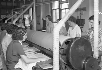 a group of women working on a machine in a factory