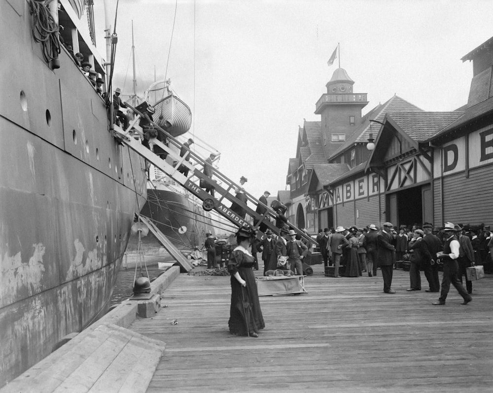 a black and white photo of people on a dock