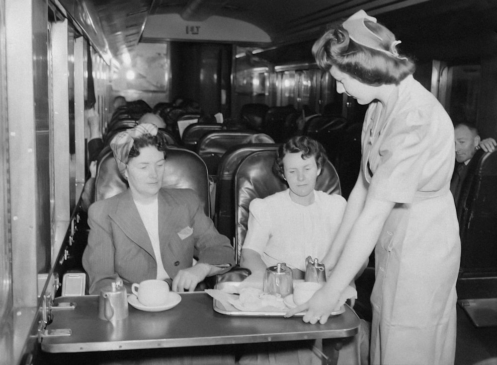 a black and white photo of a woman serving food