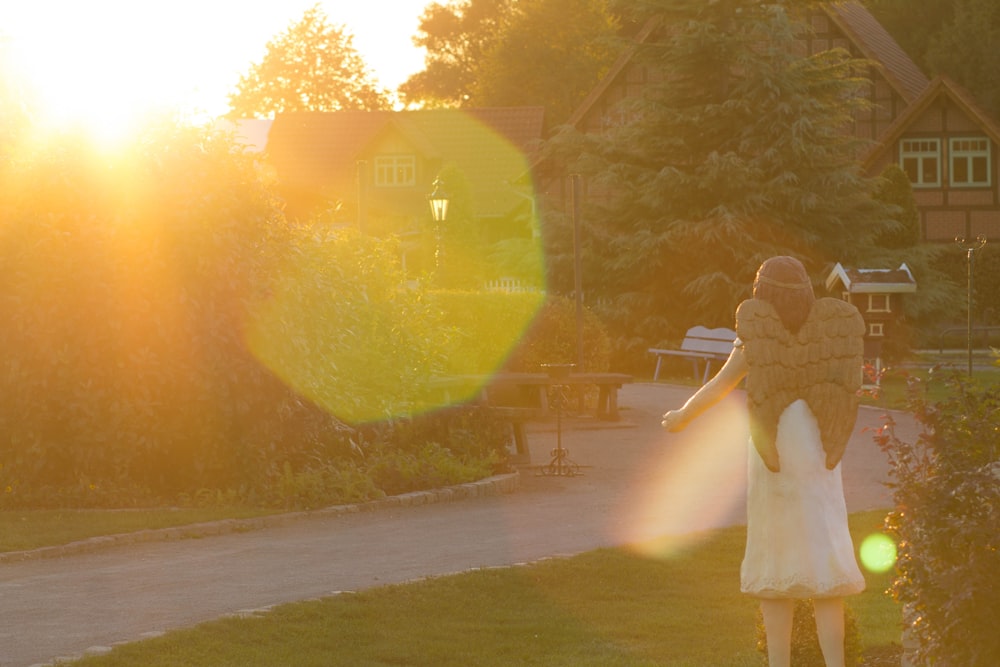 a woman in a white dress walking down a path