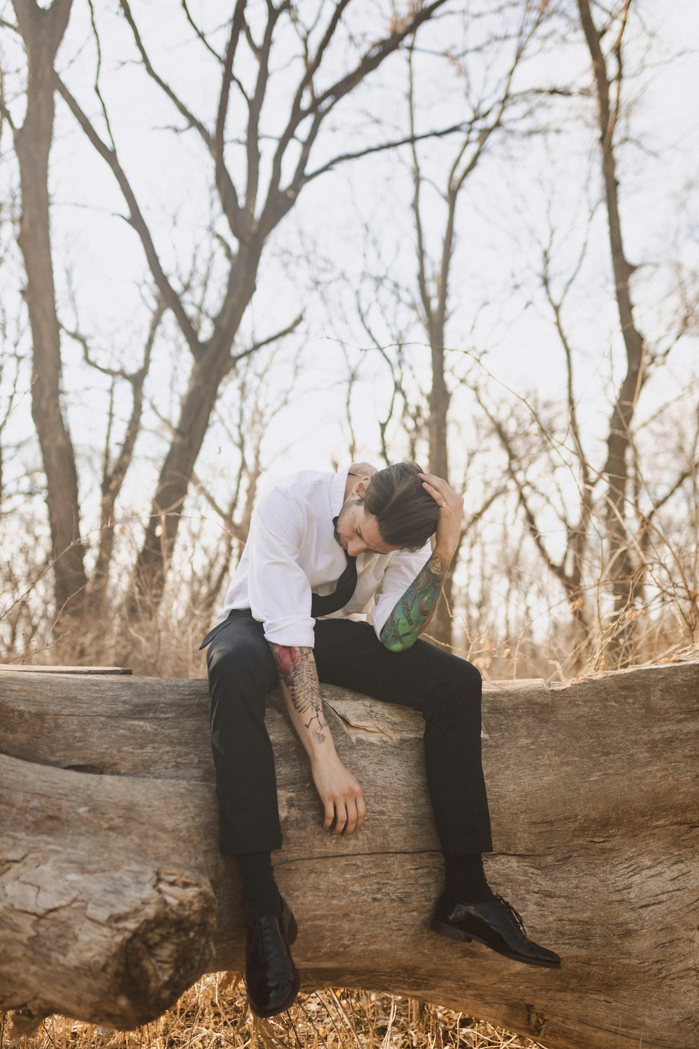 a man sitting on a log in the woods