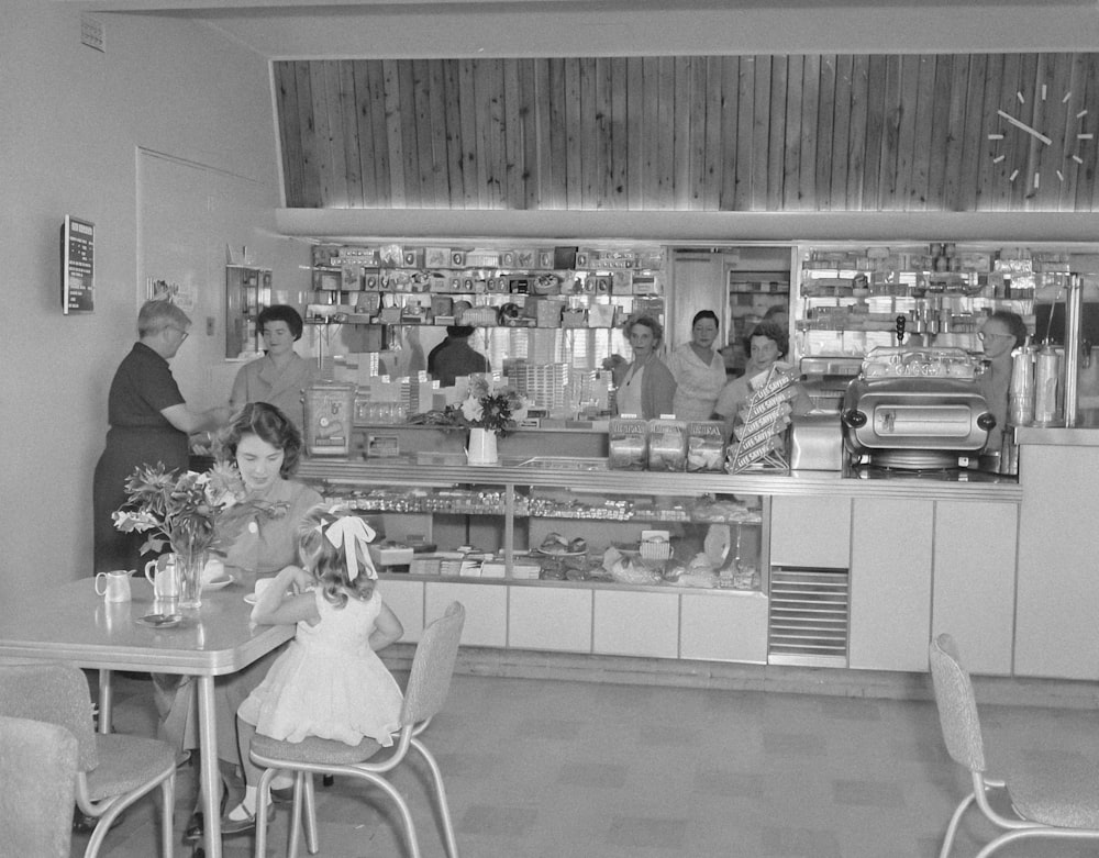a black and white photo of people in a restaurant