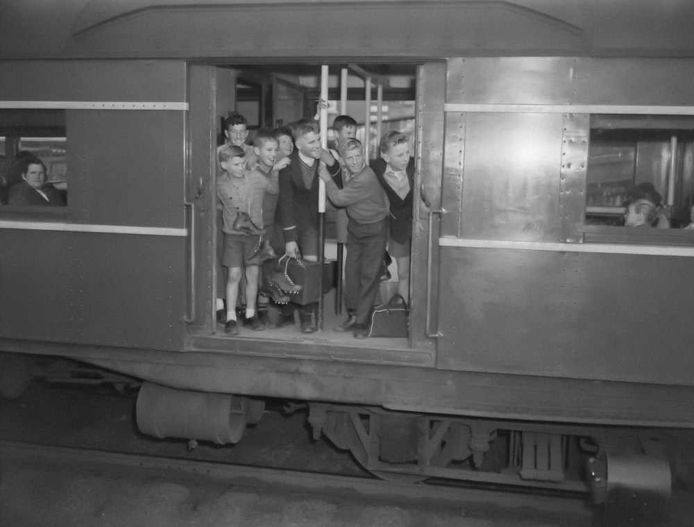 a black and white photo of a group of people on a train