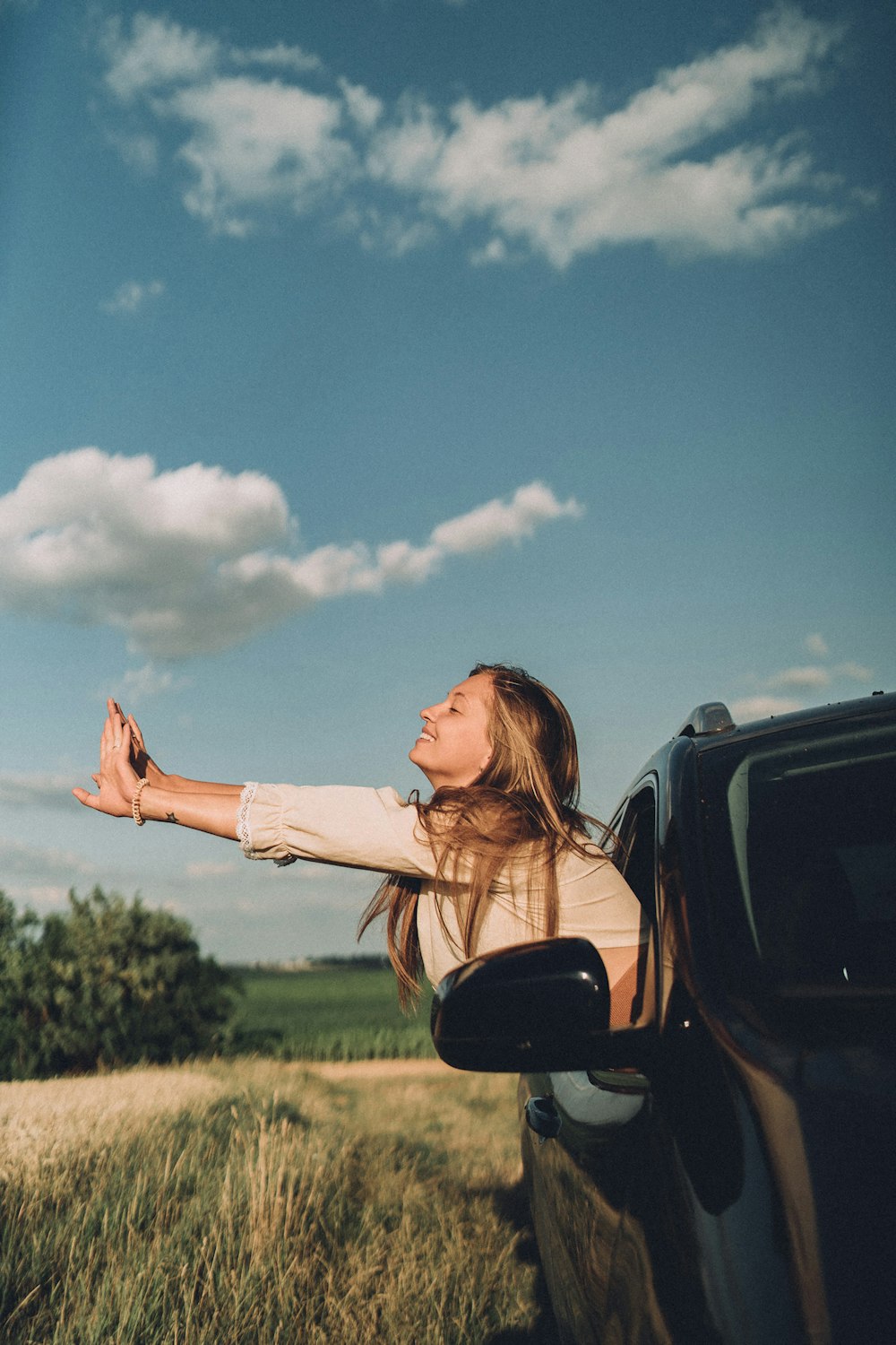 a woman reaching out of a car window