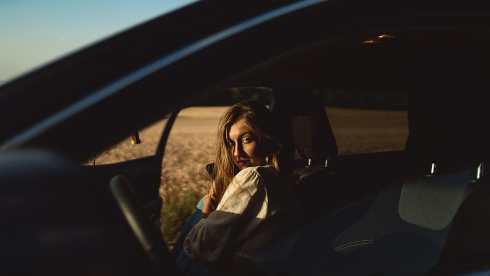 a woman sitting in the passenger seat of a car